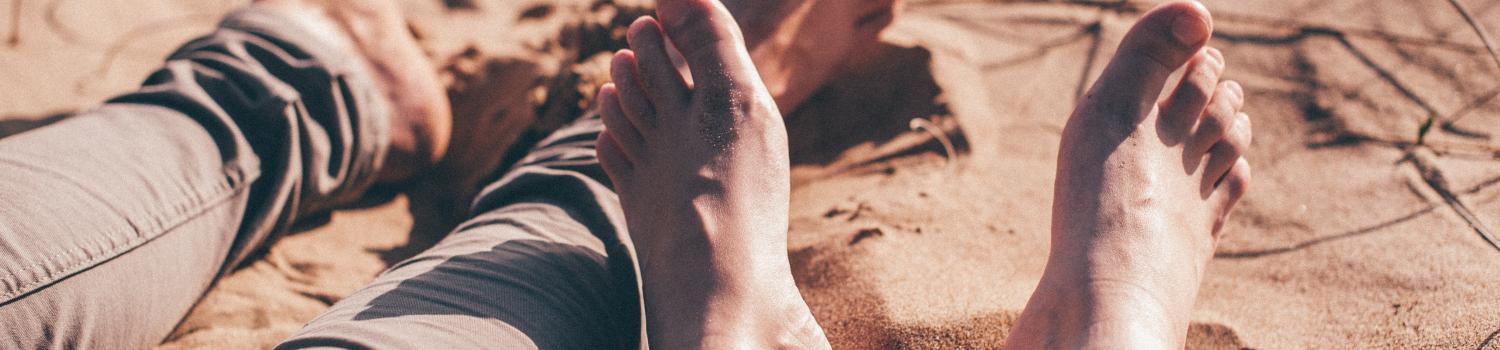 a picture of two feet resting in the sand