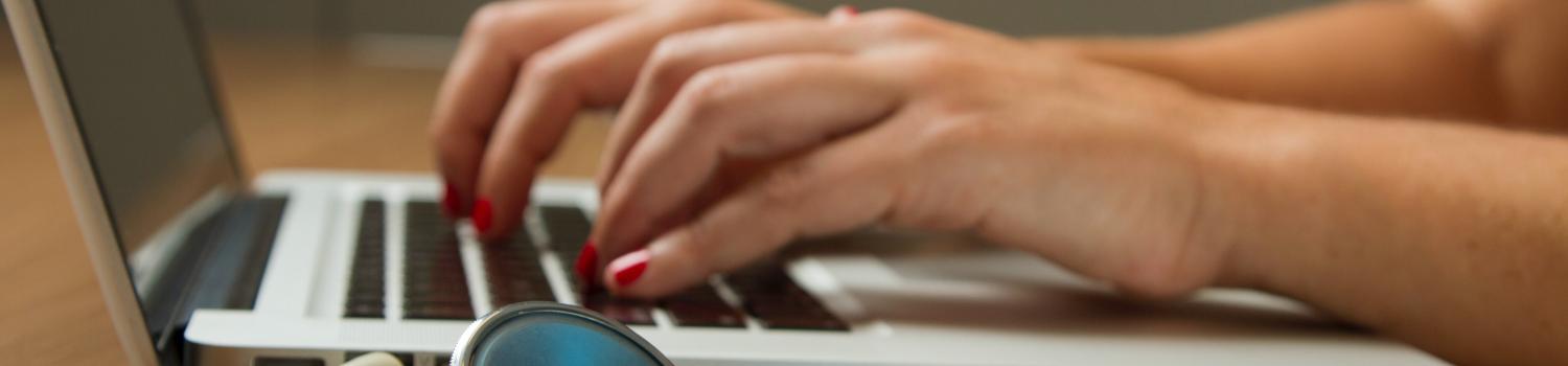 picture of a stethoscope next to a laptop